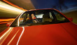 © Duncan Andison - A man driving a red sports car at night.