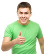 © Serhiy Kobyakov - Cheerful young man showing thumb up sign
