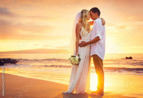 Fototeppich - Bride and Groom, Kissing at Sunset on a Beautiful Tropical Beach (von EpicStockMedia)