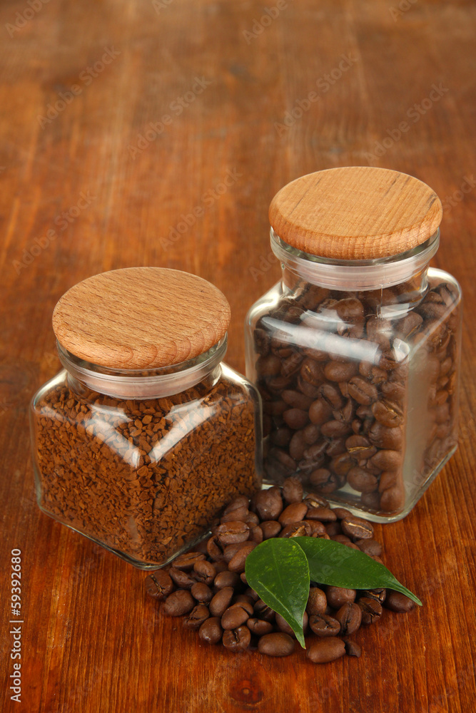 Jars of different coffee on wooden background