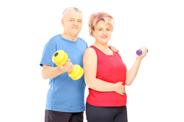 Poster - Mature man and woman holding dumbbells and looking at camera