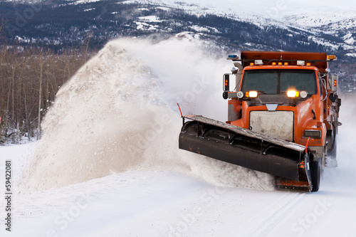 Cuadros en Lienzo Snow plough clearing road in winter storm blizzard