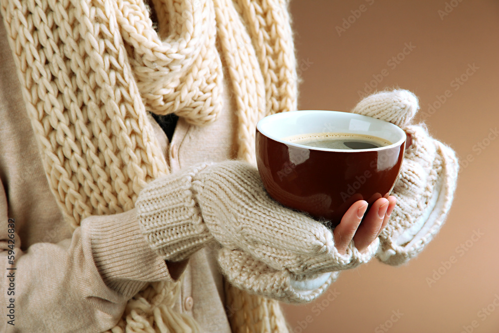 Female hands with hot drink, on color background