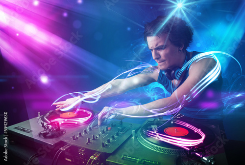 Plakat na papierze fotorealistycznym Energiczny dj miksujący muzykę z potężnymi efektami świetlnymi