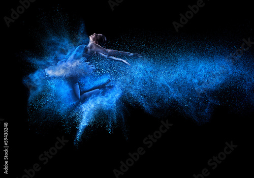 Fotografía Young beautiful dancer jumping into blue powder cloud