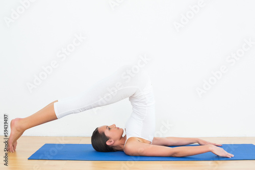 Tapeta ścienna Pasuje kobieta robi pług postawy w studio fitness