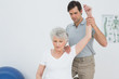 © lightwavemedia - Male physiotherapist stretching a senior woman's arm
