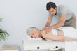 © lightwavemedia - Male physiotherapist massaging a senior woman's back