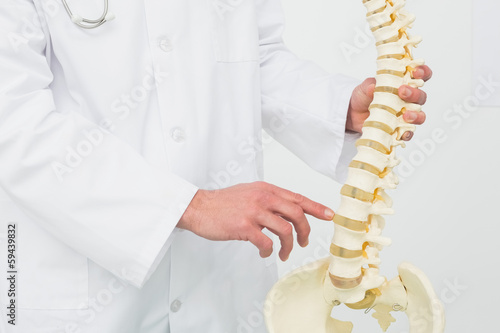 Fotografia Mid section of a male doctor with skeleton model