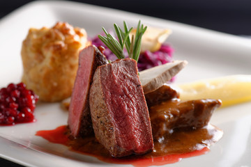 Venison meat steak with red cabbage, cranberries, herbs