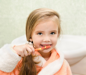 Wall Mural - Smiling little girl brushing teeth