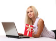 © lenets_tan - lying girl with laptop and gift isolated on white background.