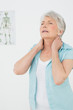 © lightwavemedia - Senior woman suffering from neck pain in medical office