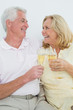 © lightwavemedia - Senior couple with champagne flutes at home