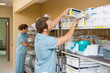 Leinwandbild Motiv Nurses Arranging Stock In Storage Room