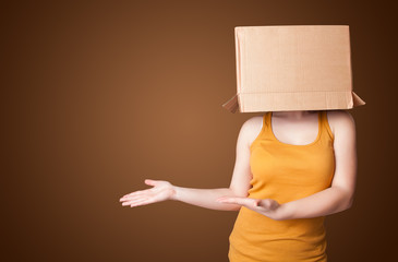 Young girl gesturing with a cardboard box on his head