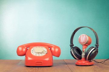 Fototapete - Retro red microphone, headphones and telephone on table