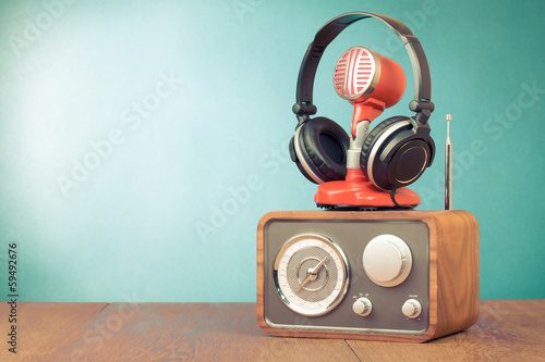 Obraz na płótnie canvas Radio retro, czerwony mikrofon, słuchawki na stole zdjęcie starego stylu