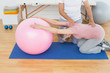 © lightwavemedia - Physical therapist assisting senior woman with yoga ball