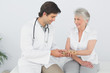 © lightwavemedia - Male physiotherapist examining a senior woman's wrist
