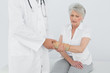 © lightwavemedia - Male physiotherapist examining a senior woman's wrist