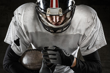 Portrait of american football player holding a ball and looking