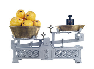 Wall Mural - Old-fashioned balance scale with quinces isolated on white