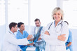 © WavebreakmediaMicro - Smiling female doctor with colleagues in meeting