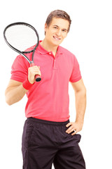 Wall Mural - Young smiling man holding a tennis racket and posing