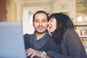 couple in love using notebook at home