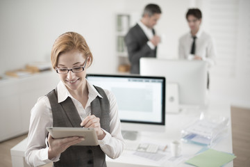 portrait of smiling businesswoman working on digital tablet