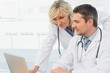 © WavebreakmediaMicro - Two concentrated doctors using laptop together