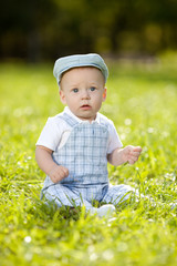 Cute little baby in summer  park on the grass. Sweet baby outdoo