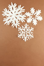 Beautiful Paper Snowflakes On Brown Background