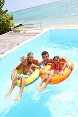 Wall Mural - Parents having fun with kids in swimming-pool