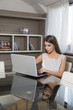 © BGStock72 - Young woman with laptop in the room