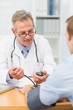 © WavebreakmediaMicro - Smiling doctor taking his patients blood pressure