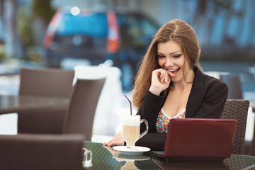 Wall Mural - portrait of a young woman in a cafe with a laptop