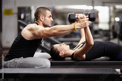 Obraz w ramie Personal trainer helping woman at gym