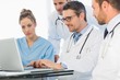 © WavebreakMediaMicro - Group of concentrated doctors using laptop