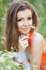 Wall Mural - Beautiful young woman on the meadow with white flowers