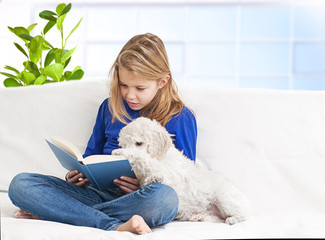 A girl reading a book little puppies