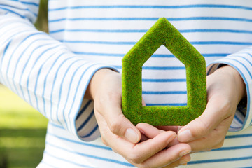 Fototapete - Hand holding green house icon