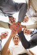 © WavebreakmediaMicro - Happy business team looking down at the camera with hands togeth