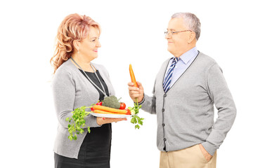 Sticker - Middle aged couple standing close together and holding a healthy