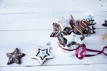 Gingerbread star cookies decorated for Christmas on wooden backg