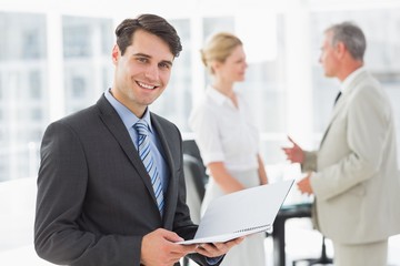 Businessman reading over a document smiling at camera