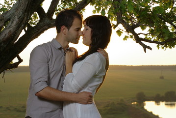 Couple kissing under tree