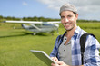 © goodluz - Adventurer using digital tablet in aerodrome