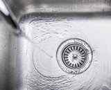 Fototapeta Tulipany - Water flowing down the hole in a kitchen sink